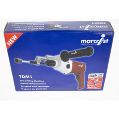 Blue retail box for a Marcist TDM1 tile drilling machine, showing the drill machine pictured on the front and product details including 230 Volts and 110W.