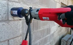 Red and black core drill against a stone wall